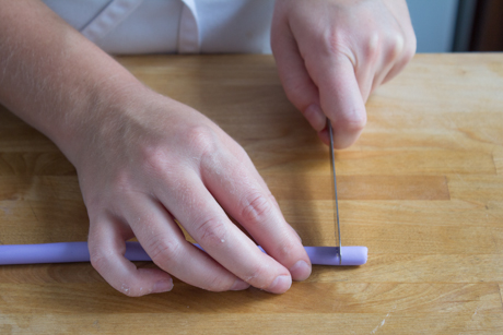 4. Next using a different colour or same colour of fondant roll a slightly thinner line of fondant and cut into one inch pieces.