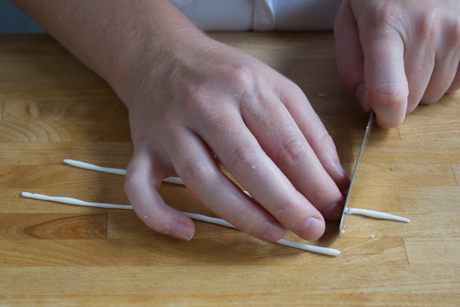 8. Now it is time to make the handle. To do this roll a very thin line of fondant into a log and cut about an inch. Form the log into a €œ9€ shape dip in a little bit of water and attach to the side of the teapot.