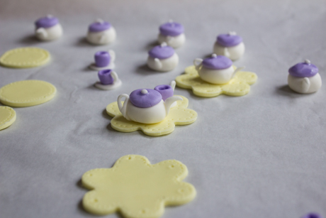 13. With your finger dab a little water onto the fondant cutout and place the teapot onto it.