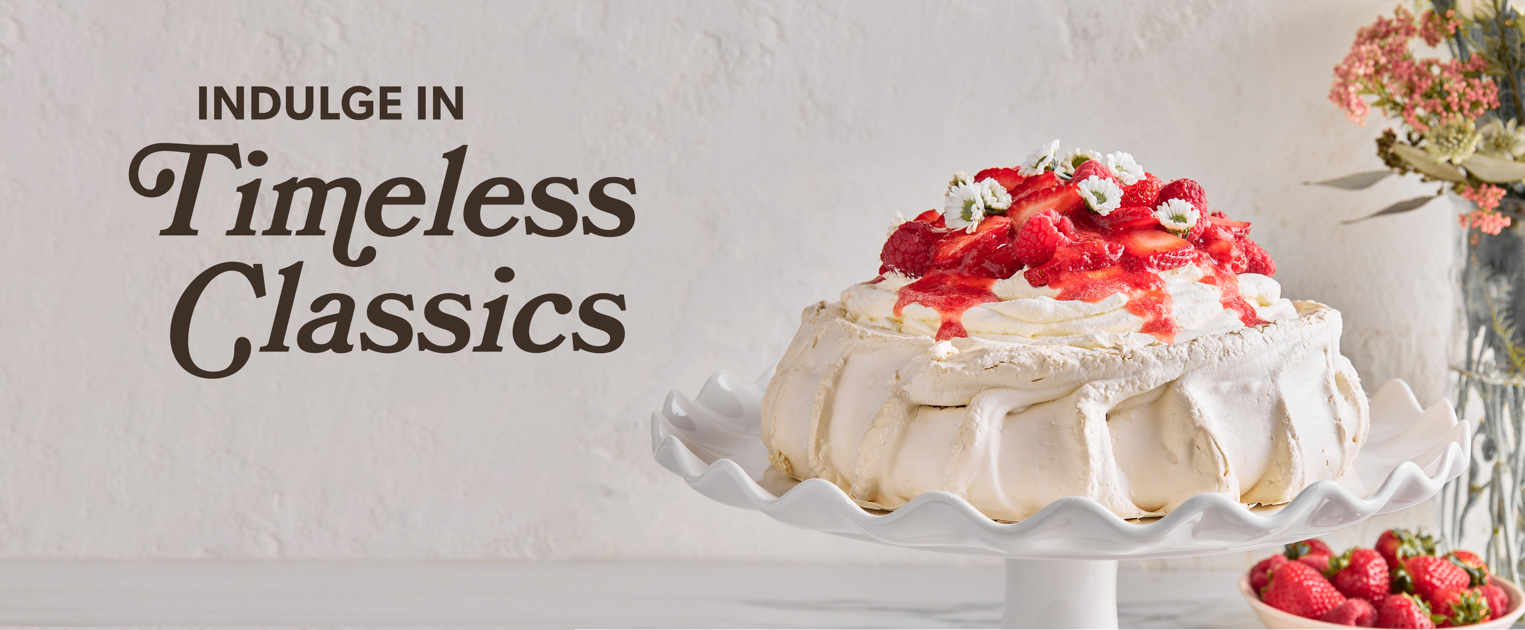 Pavlova with berries with text Indulgence in Timeless Classics