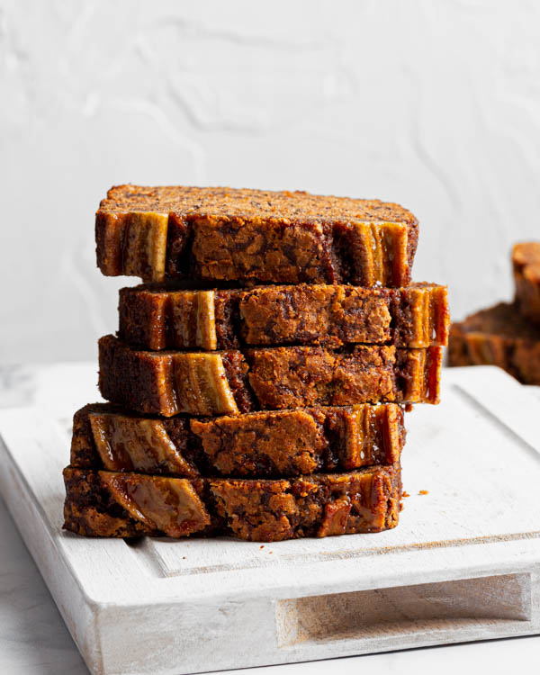Banana bread slices stacked on a cutting board
