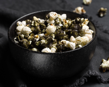 Black matcha caramel corn in a black bowl