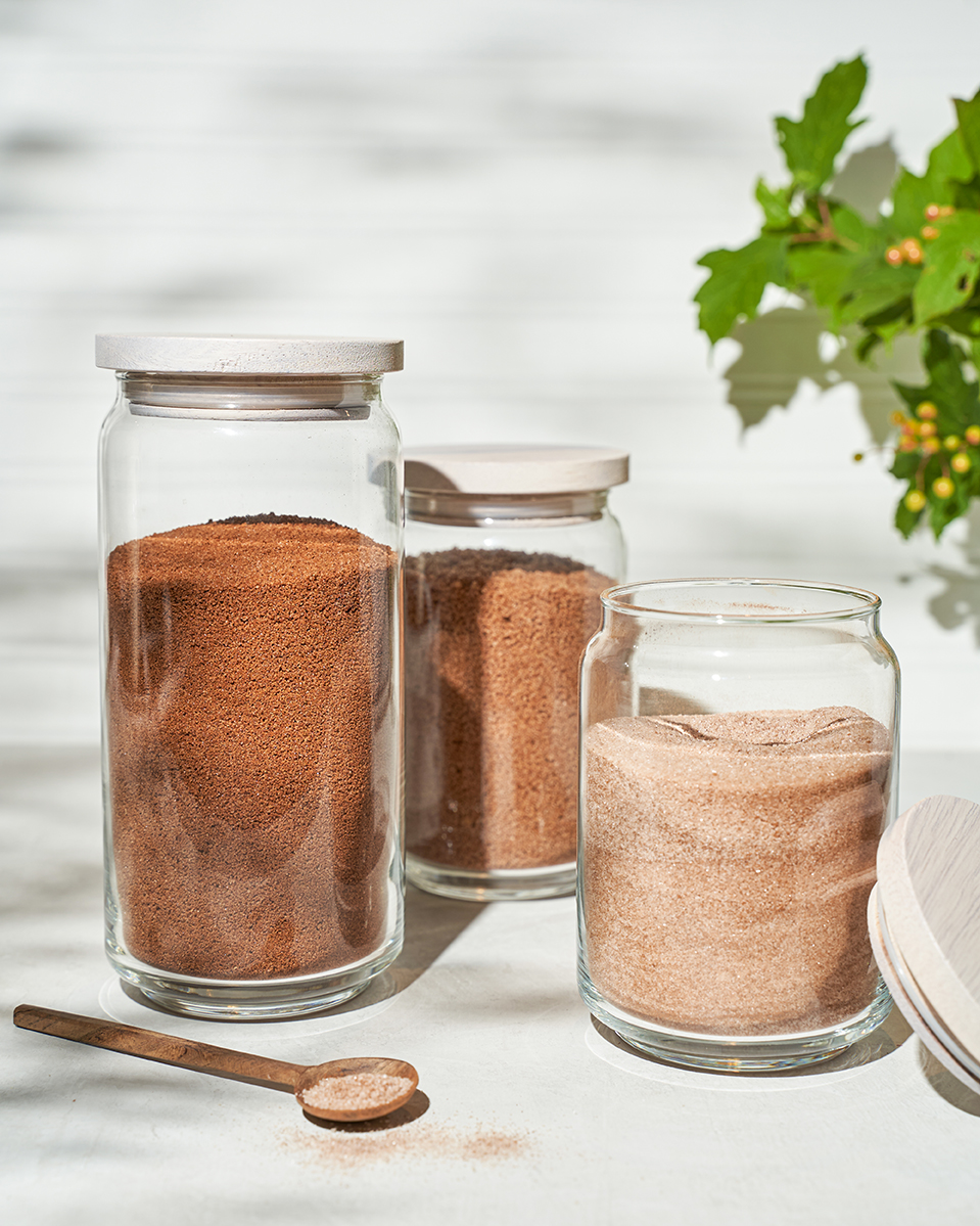 Three jars of brown cinnamon sugar, one with the lid off