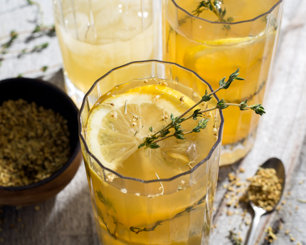Top view of a glass of lemonade garnished with thyme