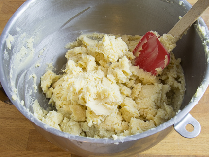Raw dough in a mixing bowl with a silicone spatula