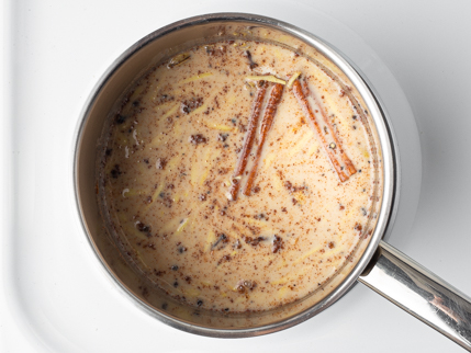 Cinnamon sticks and spices in a pot of buttermilk and heavy cream