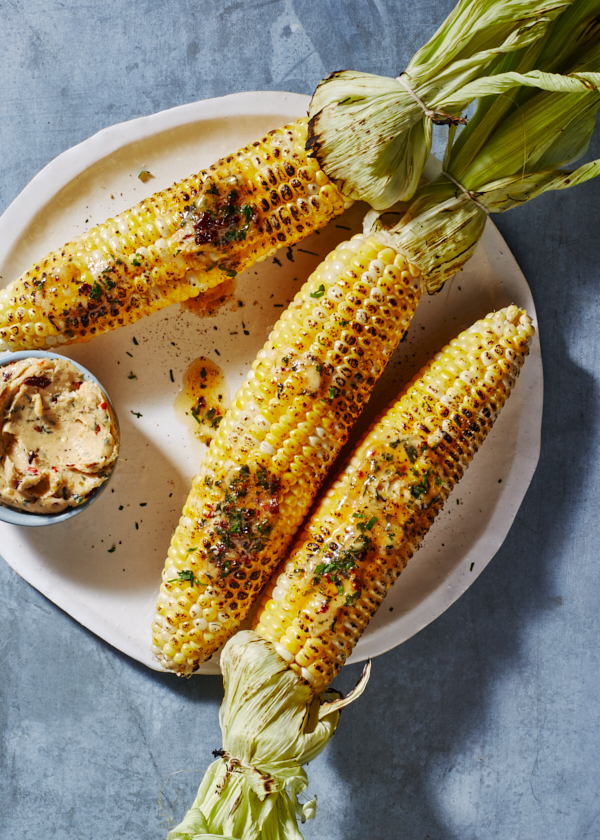 Grilled corn on the cob on a platter with a bowl of chipotle-lime butter