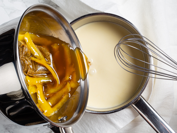 Pouring lemon and sugar syrup with chamomile into a pot of warm cream