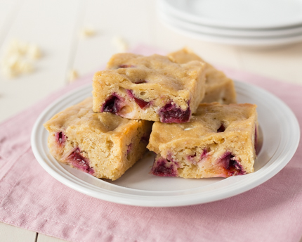 Lentil Blondies with White Chocolate and Plums stacked on a white plate