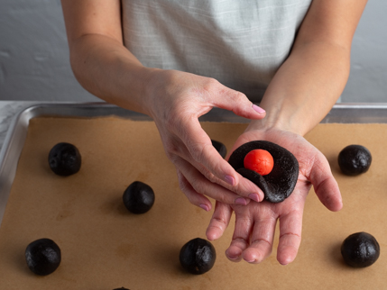 Folding a ball of marzipan into a disc of dark chocolate cookie dough