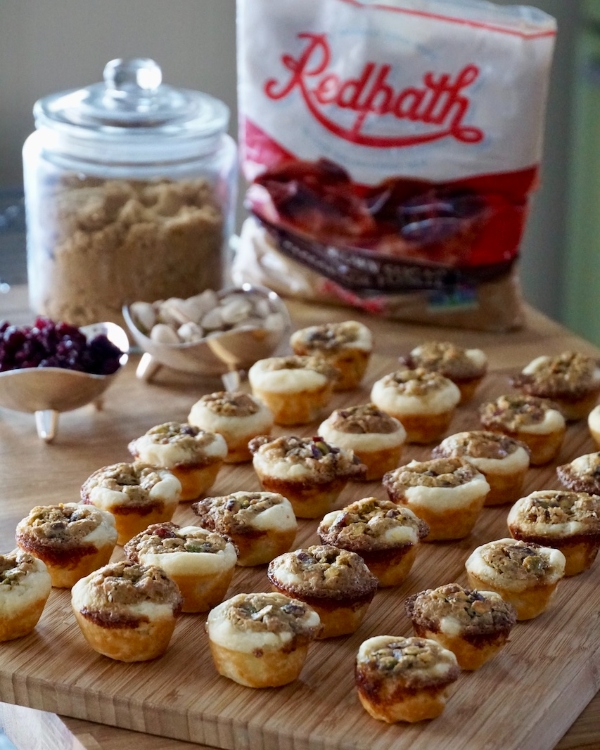Mini fruit and nut tarts on wooden cutting board