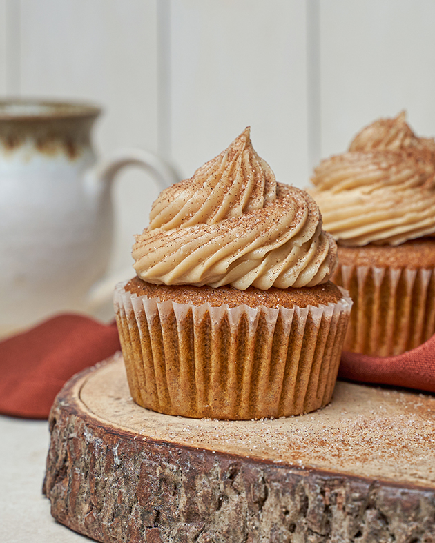 Pumpkin spice cupcakes with frosting on a live edge wood serving tray