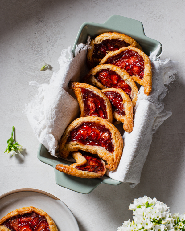 Strawberry date galette crescents in a loaf pan lined with a tea towel