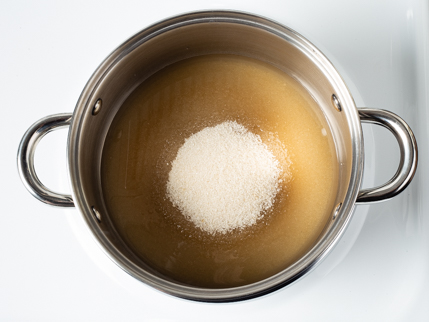 Sugar starting to melt in a pot on a stove