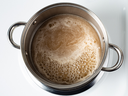 Simmering sugar in a pot on a stove
