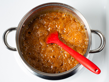 Boiling sugar and heavy cream in a pot on a stove