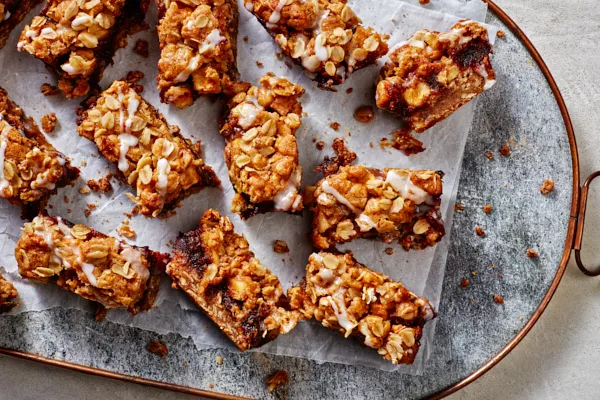 Apple Date Crumble Bars served on a piece of folded parchment on a blue tray