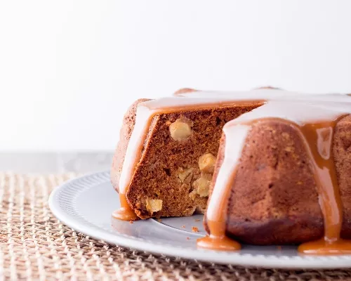 Sliced Bundt cake glazed with caramel served on a white plate