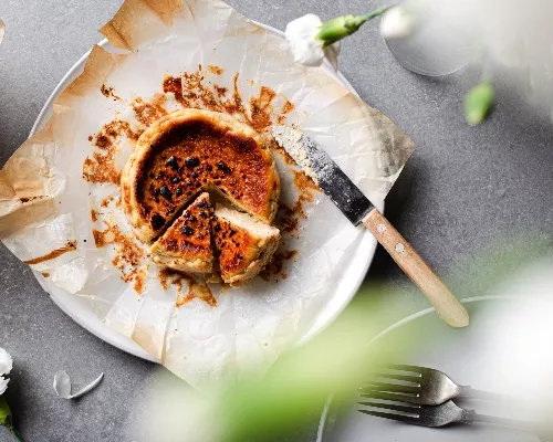 Top view of a Mini Basque cheesecake on a plate with two pieces cut out