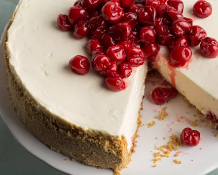 A cherry cheesecake with a slice missing