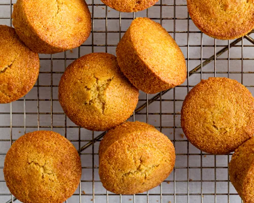 Cornmeal Muffins on a wire cooling rack with a light green cloth