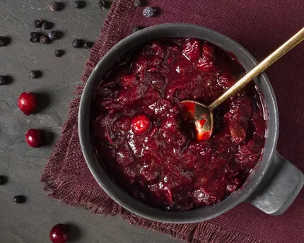 Spiced Marsala Wine Cranberry Sauce in a grey bowl surrounded by loose cranberries