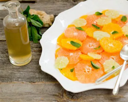 Ginger Mint Citrus Salad in a white bowl with a side of dressing