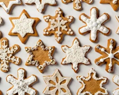 Rows of iced Gingerbread Spiced Cookies in snowflake and star shapes