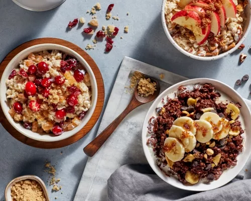 Three bowls of homemade oatmeal with brown sugar, fruit, and berries