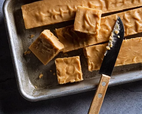 Brown sugar fudge in a baking pan sliced into pieces