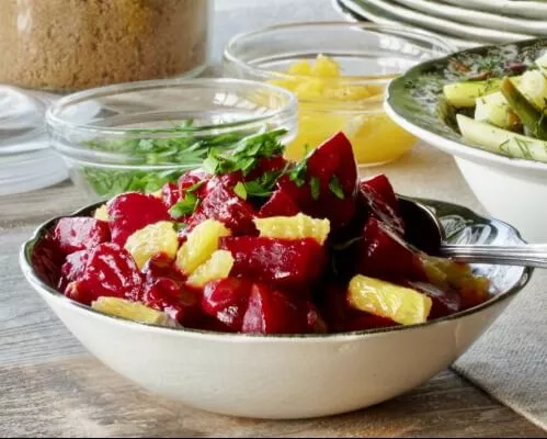 A bowl of orange and glazed beets
