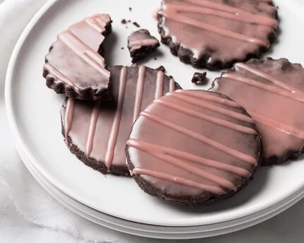 Chocolate cookies with a dark pink glaze on a plate