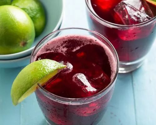 Red Sorrel Drink garnished with a lime slice