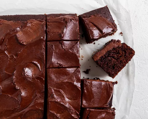 Vegan chocolate slab cake with chocolate icing cut into squares