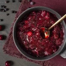 Spiced Marsala Wine Cranberry Sauce in a grey bowl surrounded by loose cranberries