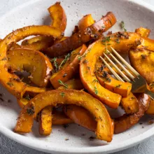 Roasted pumpkin sections in a dish with seasoning