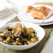 caramelized brussel sprouts in a white bowl with a spoon