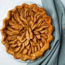 Full dutch apple pie sitting on a blue napkin