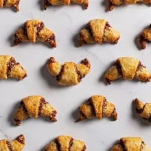 Chocolate tahini rugelach crescents arranged on a marble counter