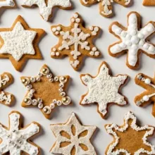 Rows of iced Gingerbread Spiced Cookies in snowflake and star shapes