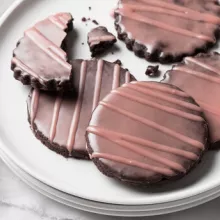 Chocolate cookies with a dark pink glaze on a plate