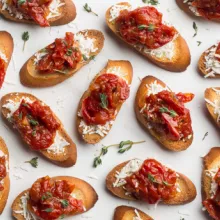 Crostini with tomato jam artfully displayed with fresh herbs