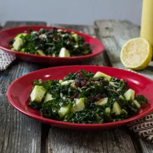 Two red bowls with Apple Kale Salad with Lemon Poppy Seed Vinaigrette
