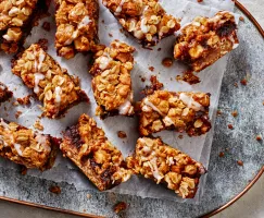 Apple Date Crumble Bars served on a piece of folded parchment on a blue tray