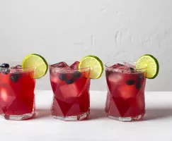 Three glasses of Blueberry Beer Cocktail garnished with blueberries and lime