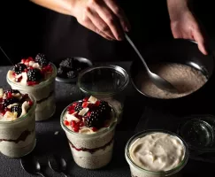 Vanilla cardamom chia pudding in a cup garnished with blackberries, coconut and pomegranate