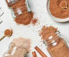 Three jars of cinnamon sugar spilled on a table