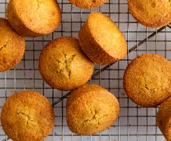 Cornmeal Muffins on a wire cooling rack with a light green cloth