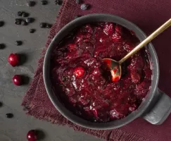 Spiced Marsala Wine Cranberry Sauce in a grey bowl surrounded by loose cranberries