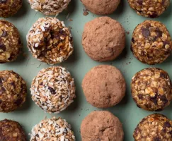 Fruit & Nut energy bites lined up on a painted wood background